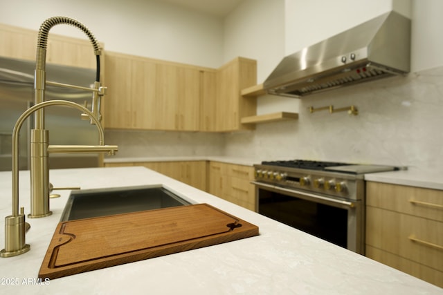 kitchen with sink, high end range, tasteful backsplash, exhaust hood, and light brown cabinets