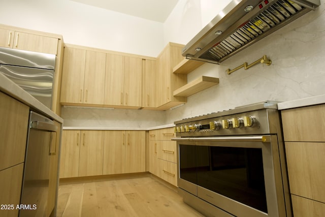 kitchen with light brown cabinetry, stainless steel stove, custom exhaust hood, and light wood-type flooring