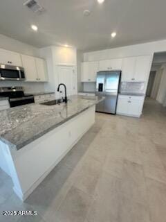 25336 W Bowker St, Buckeye, AZ 85326 - kitchen with visible vents, white cabinets, a sink, appliances with stainless steel finishes, and light stone counters
