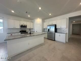 25336 W Bowker St, Buckeye, AZ 85326 - kitchen featuring white cabinets, a center island with sink, a sink, and appliances with stainless steel finishes