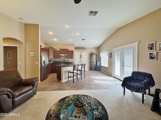 living room featuring french doors, light colored carpet, and lofted ceiling