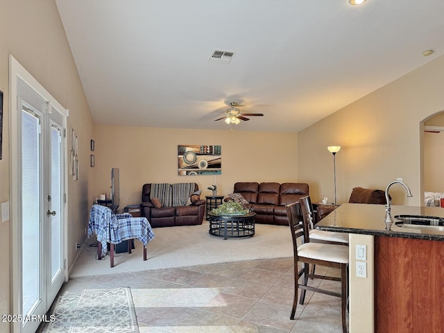 living room featuring light colored carpet, ceiling fan, and sink