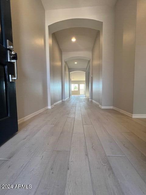 corridor with light hardwood / wood-style floors