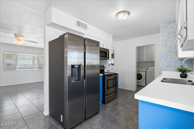 kitchen with ceiling fan, separate washer and dryer, sink, appliances with stainless steel finishes, and white cabinetry