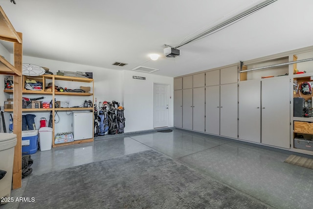 garage featuring a garage door opener and visible vents