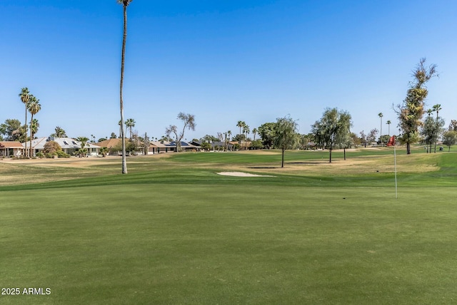 view of community featuring golf course view and a lawn