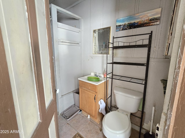 bathroom with toilet, tile patterned floors, and vanity