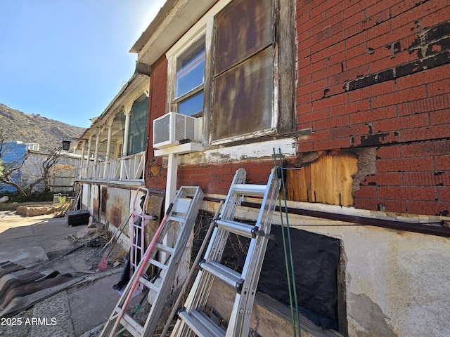 view of property exterior with a mountain view, cooling unit, and brick siding