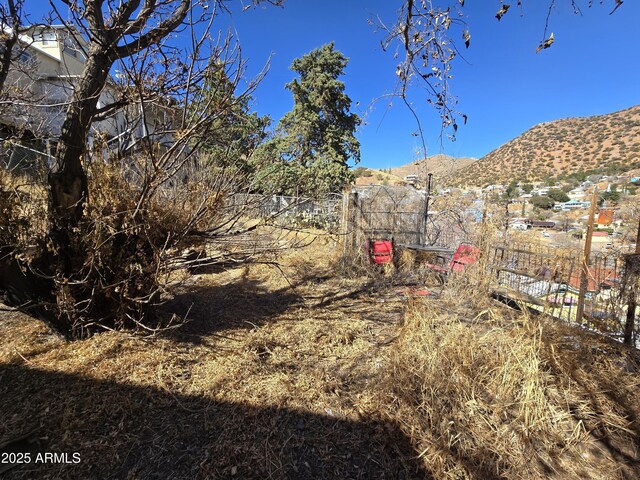 view of yard featuring fence and a mountain view