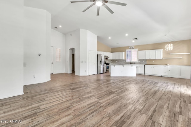 3044 E Sparrow Pl, Chandler, AZ 85286 - unfurnished living room featuring arched walkways, a sink, ceiling fan with notable chandelier, and light wood-type flooring