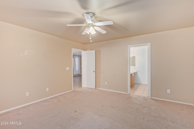 unfurnished bedroom featuring light carpet, ceiling fan, and connected bathroom