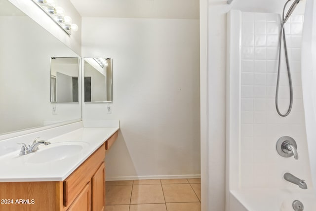 bathroom with tiled shower / bath combo, vanity, and tile patterned flooring