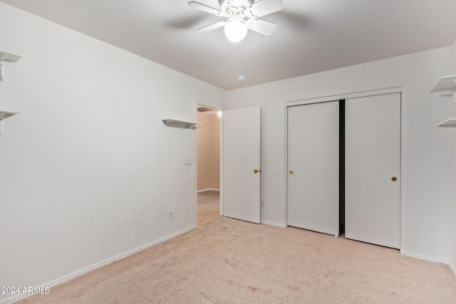 unfurnished bedroom featuring light carpet, ceiling fan, and a closet