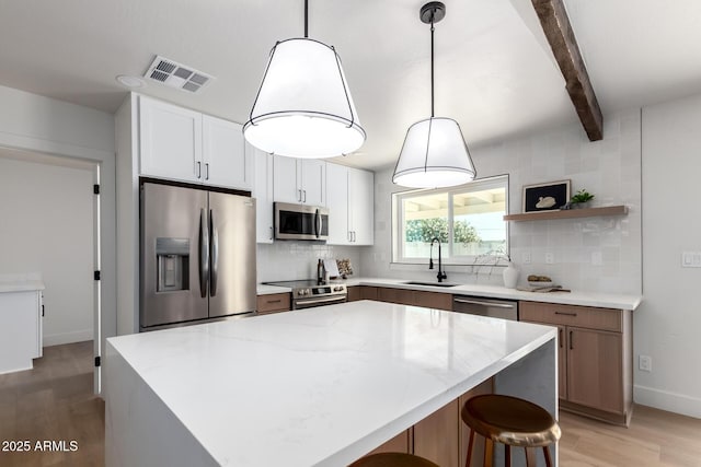 1736 N Ashbrook Cir, Mesa, AZ 85213 - kitchen featuring appliances with stainless steel finishes, a sink, light wood finished floors, tasteful backsplash, and beamed ceiling