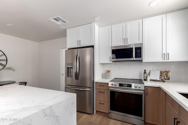1736 N Ashbrook Cir, Mesa, AZ 85213 - kitchen featuring stainless steel appliances, light wood-style floors, backsplash, white cabinetry, and recessed lighting