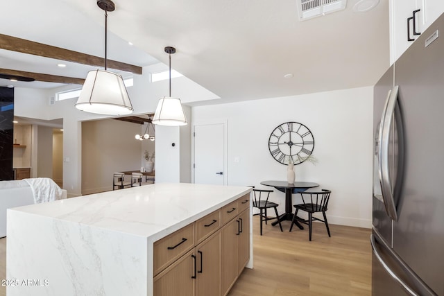 1736 N Ashbrook Cir, Mesa, AZ 85213 - kitchen featuring freestanding refrigerator, light wood finished floors, pendant lighting, a kitchen island, and light stone countertops