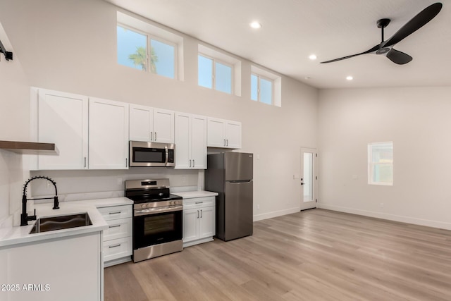 1736 N Ashbrook Cir, Mesa, AZ 85213 - kitchen with stainless steel appliances, a high ceiling, a sink, ceiling fan, and white cabinetry