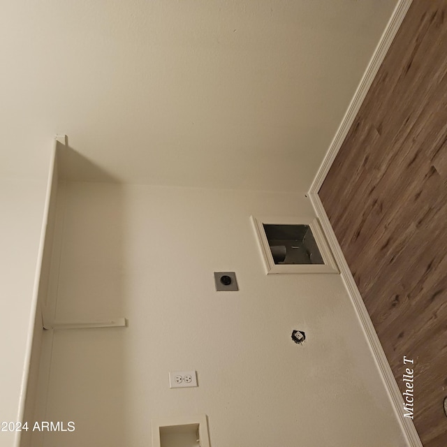 laundry room with ornamental molding, wood walls, and electric dryer hookup