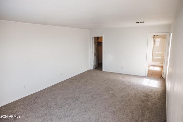 spare room featuring carpet floors and baseboards