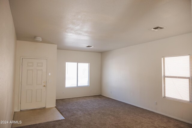 unfurnished living room with carpet and a tile fireplace