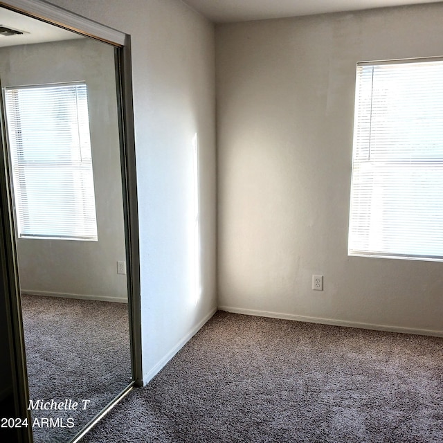 carpeted spare room featuring baseboards and visible vents