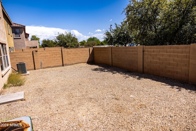 view of yard with a fenced backyard and central AC