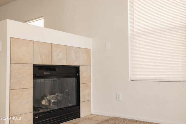 interior details featuring a tiled fireplace and tile patterned floors