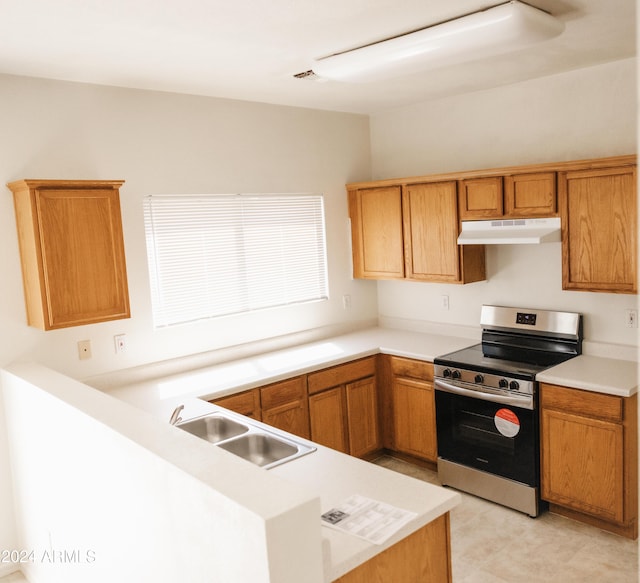 kitchen with electric stove, light countertops, a sink, and under cabinet range hood