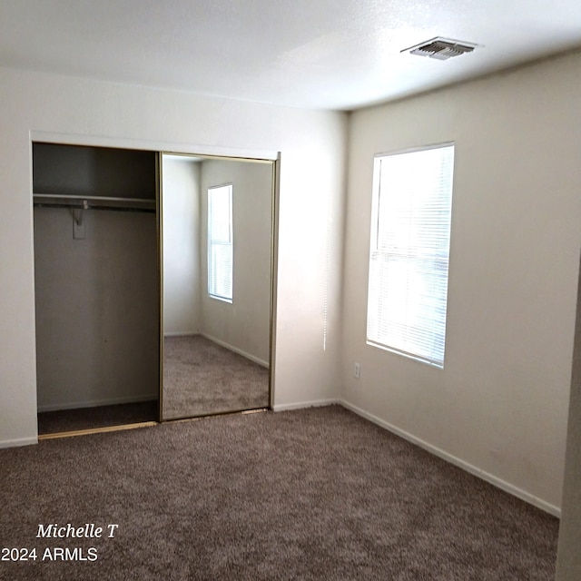 unfurnished bedroom with a closet and carpet flooring