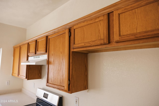 interior details with brown cabinetry, stove, and under cabinet range hood