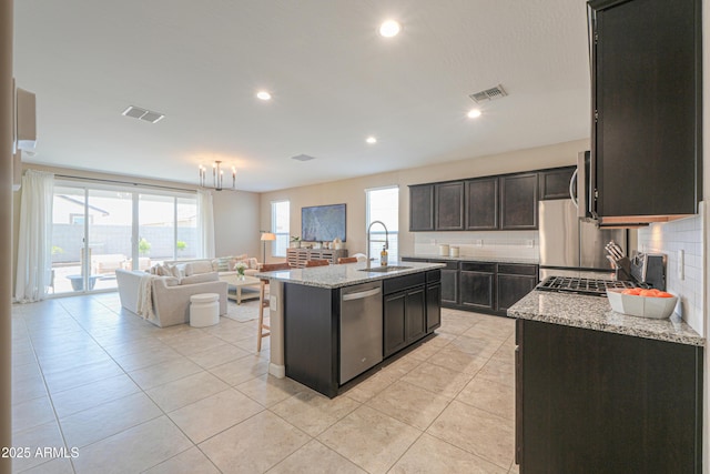 37903 W San Clemente St, Maricopa, AZ 85138 - kitchen featuring stainless steel dishwasher, a sink, open floor plan, decorative backsplash, and an island with sink