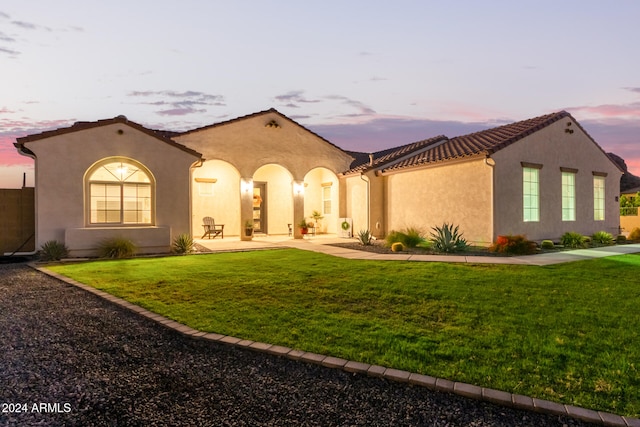 mediterranean / spanish home featuring a yard