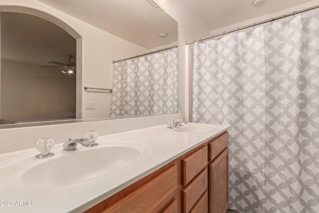 bathroom with double vanity, ceiling fan, and a sink