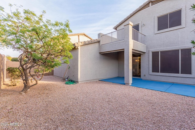 back of property with a patio area, fence, a balcony, and stucco siding