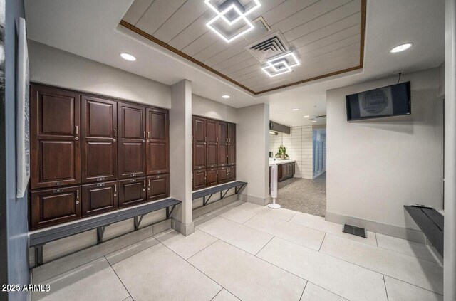 mudroom featuring a tray ceiling, baseboards, light tile patterned floors, recessed lighting, and light carpet