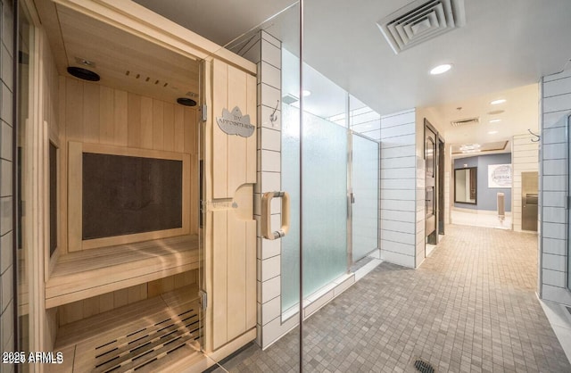 bathroom with a shower stall, tile patterned floors, a sauna, and recessed lighting
