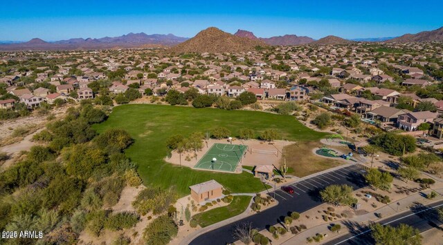 aerial view of property and surrounding area featuring a mountainous background and nearby suburban area