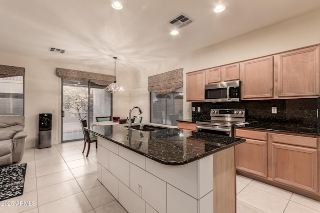 kitchen with a kitchen island with sink, visible vents, stainless steel appliances, and a sink