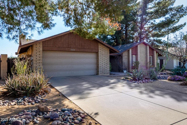 view of front of property featuring concrete driveway, an attached garage, and a chimney