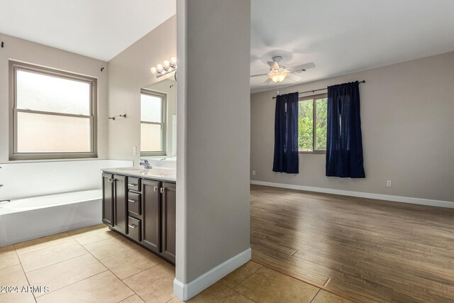 bathroom featuring wood-type flooring, vanity, a bathtub, and ceiling fan