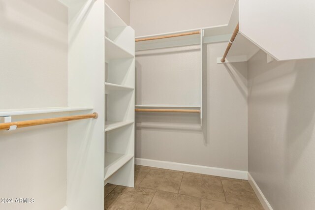 walk in closet with light tile patterned floors