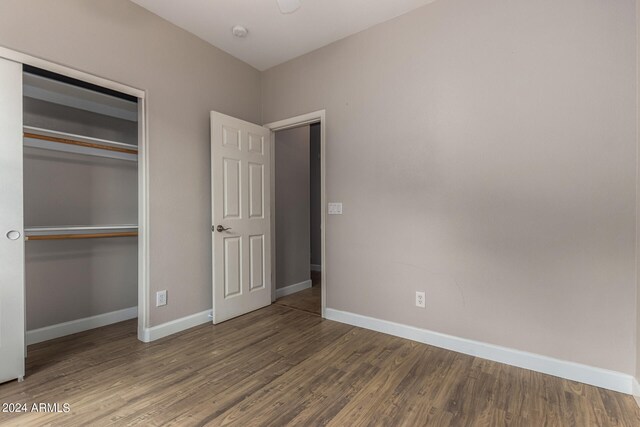 unfurnished bedroom featuring wood-type flooring and a closet