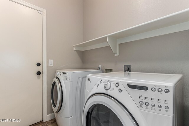 clothes washing area with washing machine and dryer