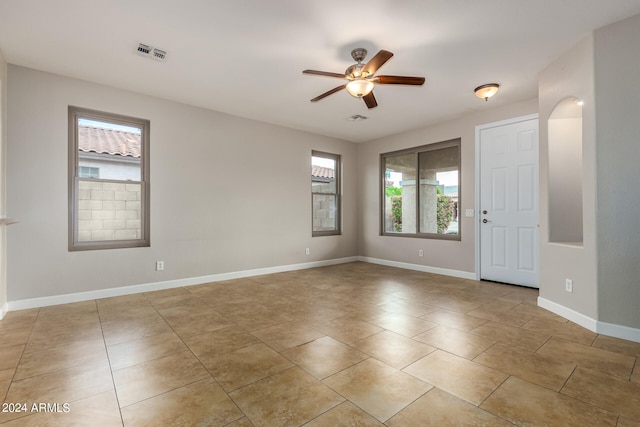 empty room featuring ceiling fan and plenty of natural light