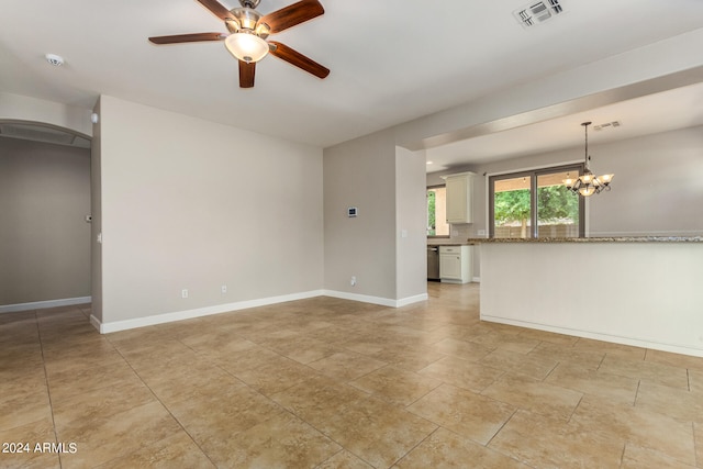 unfurnished living room featuring ceiling fan with notable chandelier