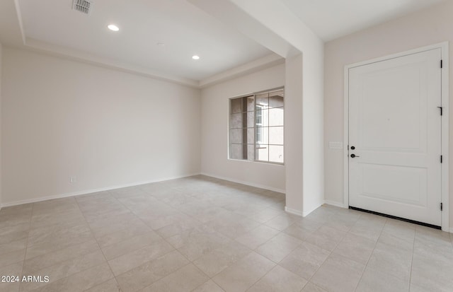 entrance foyer with light tile patterned floors and a raised ceiling