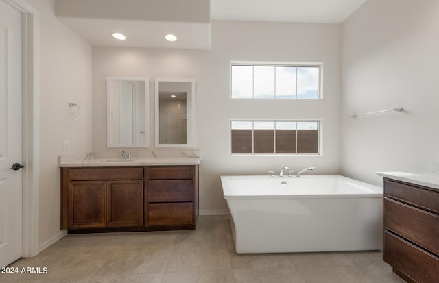 bathroom featuring vanity, tile patterned floors, and a tub