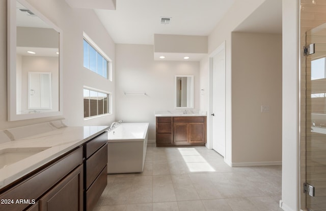 bathroom with tile patterned flooring, vanity, and shower with separate bathtub