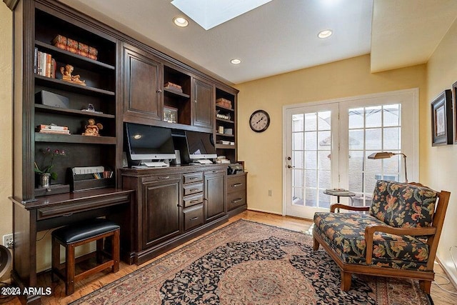 office space featuring light hardwood / wood-style floors and a skylight