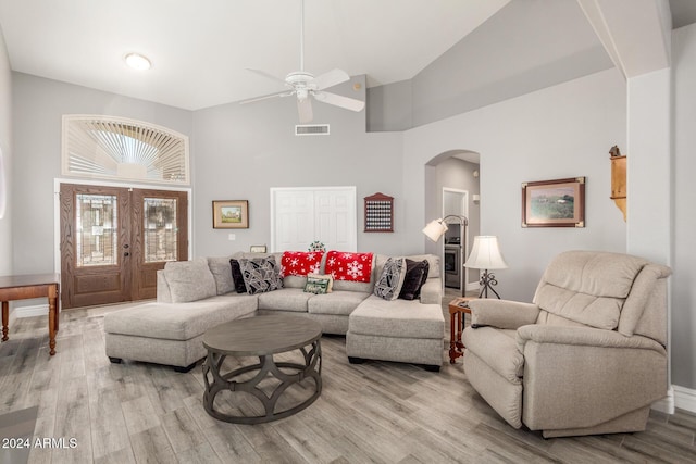 living room with ceiling fan, light hardwood / wood-style floors, and lofted ceiling